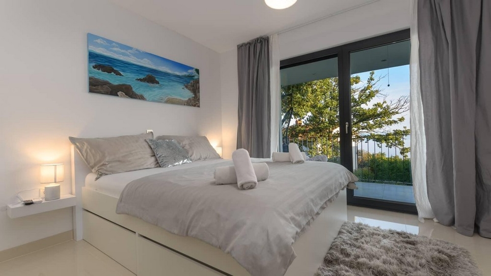 Útulná spálňa s balkónom a výhľadom na sviežu zeleň