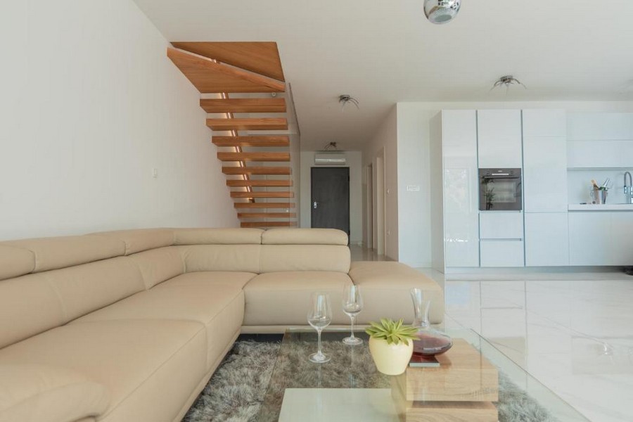 Štýlová obývacia izba s otvorenou kuchyňou a schodiskom