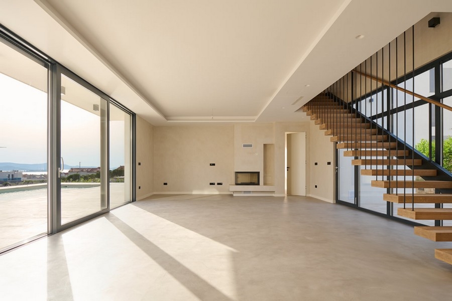 Svetlá obývačka vily v Chorvátsku s krbom a veľkými oknami na predaj