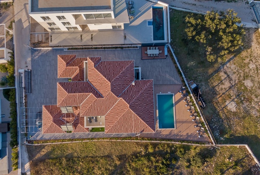 Letecký pohľad na vilu H3042, zobrazujúci jej strešnú konštrukciu a priľahlý bazén