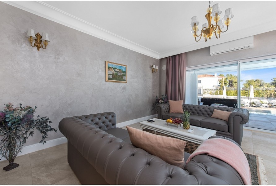 Elegantná obývacia izba vily H3042 s pohodlnými pohovkami a výhľadom na vonkajší priestor