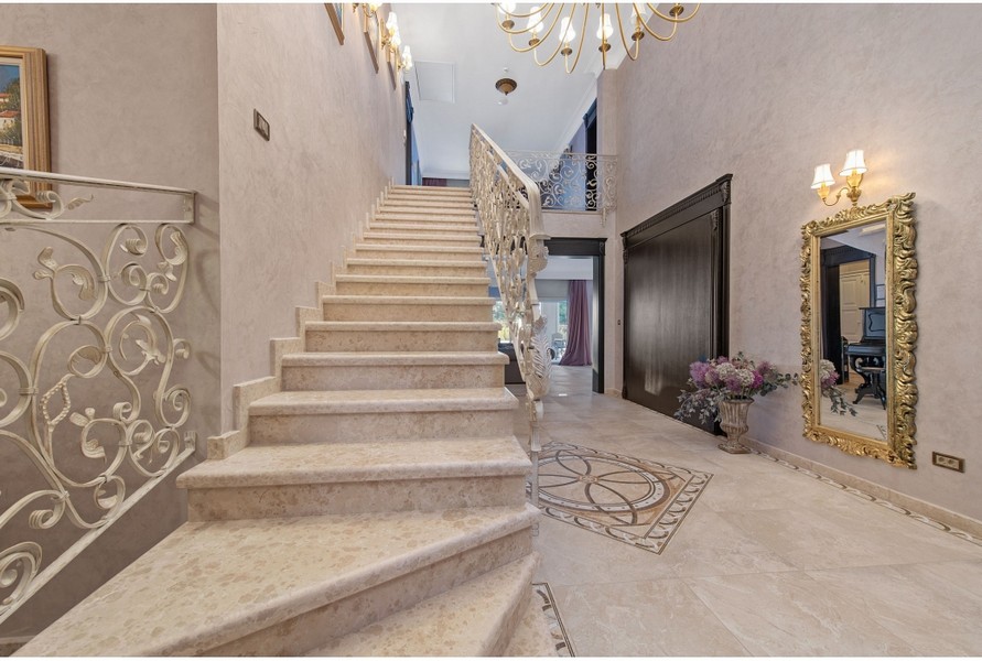 Priestranná hala vily H3042 so zdobeným schodiskom a štýlovou výzdobou