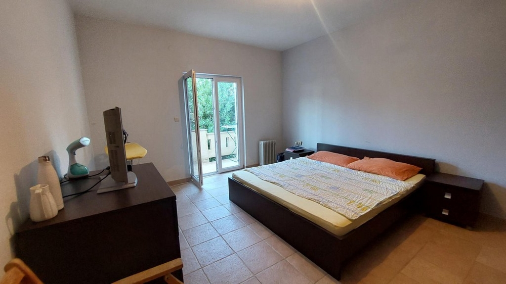 Spálňa s manželskou posteľou a prístupom na balkón v dome v Chorvátsku