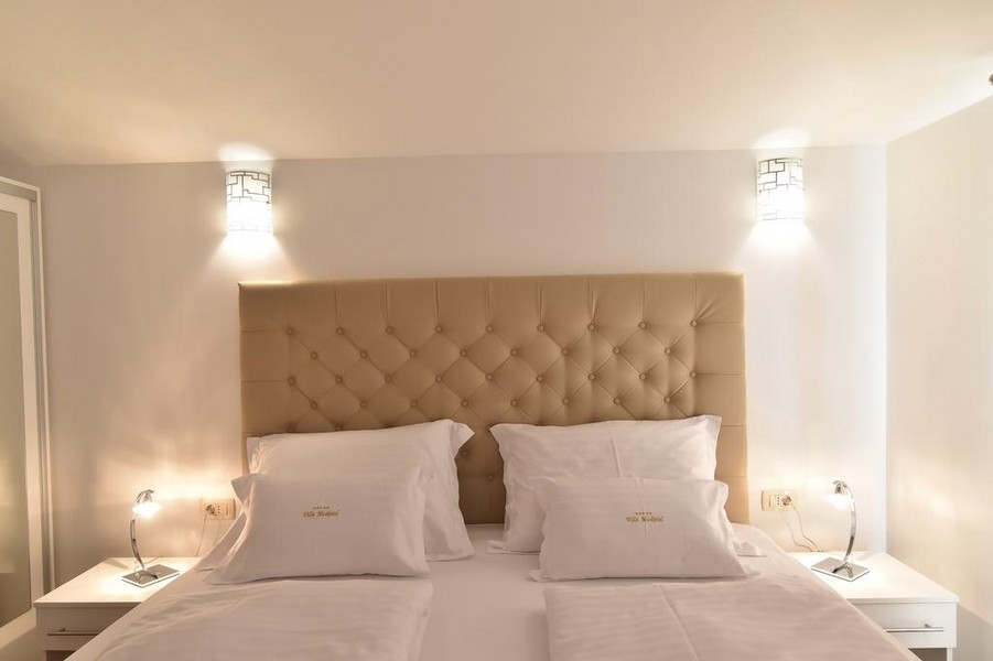 Detail postele v spálni s moderným osvetlením v ponuke realitnej kancelárie Panorama Scouting