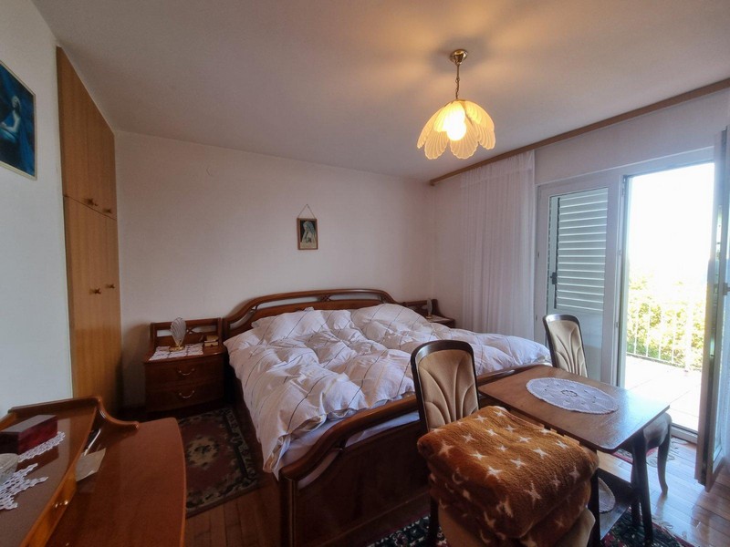 Spálňa s veľkou posteľou a prístupom na balkón v dome v meste Sveti Juraj v Chorvátsku