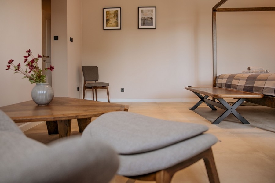 Moderná a elegantná spálňa s písacím stolom, nástennou TV a veľkým zrkadlom s jemným osvetlením a neutrálnymi tónmi