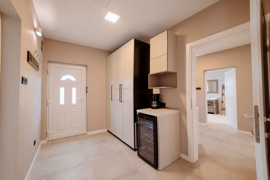 Vstupná časť s modernými skrinkami, vinotékou a výhľadom do štýlovej kúpeľne