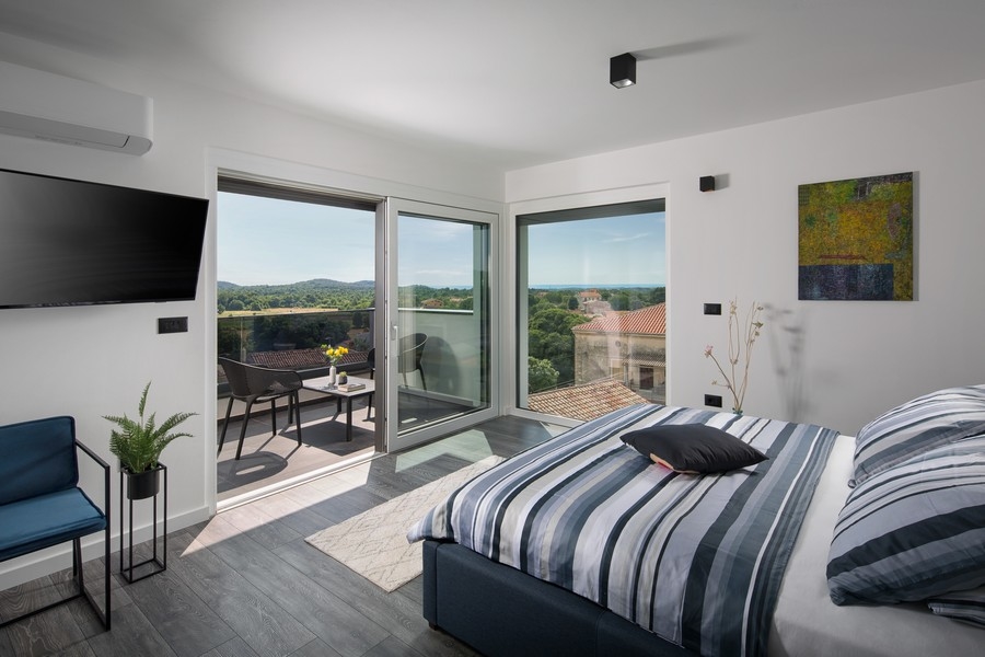 Spálňa s výhľadom na zeleň a more.