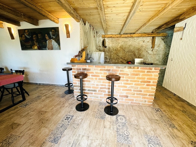 Rustikálna krčma s murovaným barom, dreveným trámovým stropom a barovými stoličkami