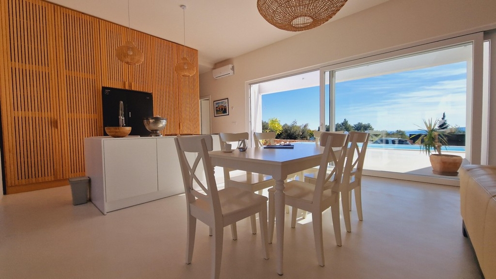 Otvorený obývací a jedálenský priestor s výhľadom na terasu a bazén vily na Krku v Chorvátsku.