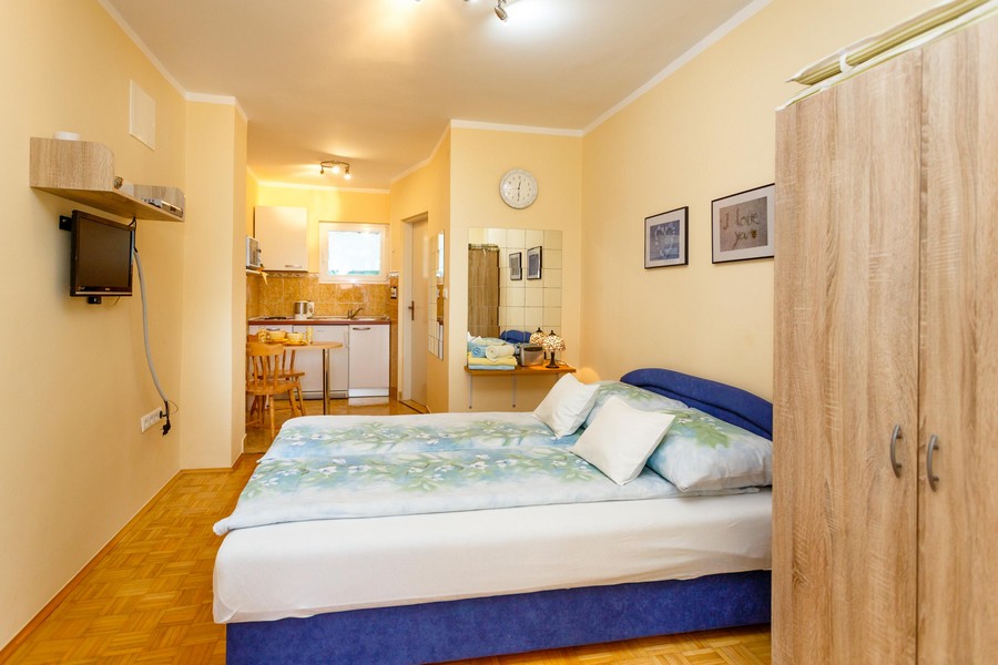 Štúdiový apartmán s manželskou posteľou, malým jedálenským stolom a kuchynským kútom