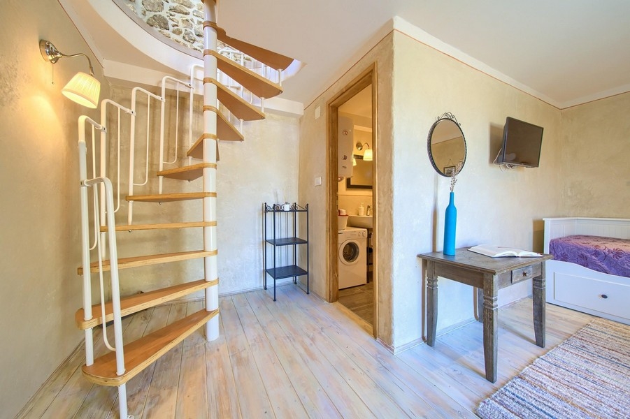 Svetlá spálňa s moderným nábytkom a prístupom do kúpeľne na prízemí.