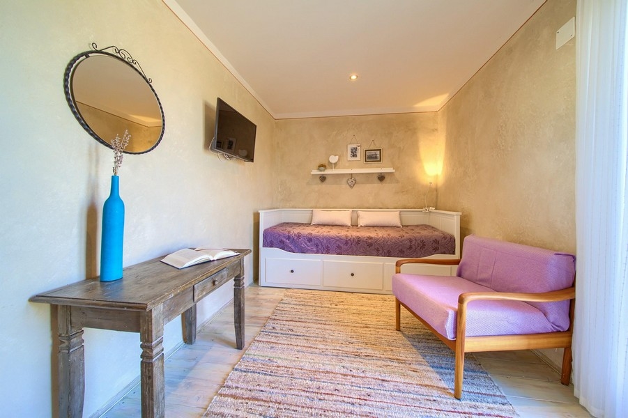 Útulná izba s rozkladacou pohovkou v dome H3415, ponúkaná na predaj na ostrove Krk v Chorvátsku.