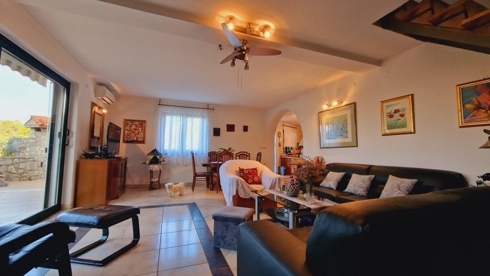 Obývacia izba s pohodlnou pohovkou, skleneným stolíkom a veľkým oknom s výhľadom na terasu