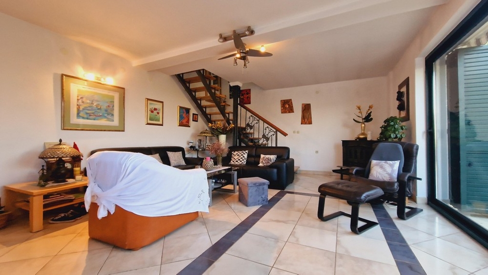 Veľká obývacia izba so schodiskom a koženým nábytkom, výhľad na terasu