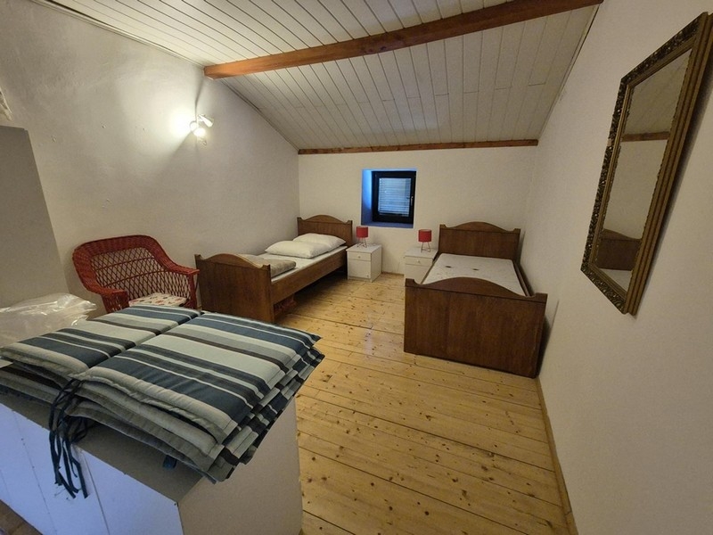 Spálňa s dvoma jednolôžkami a jednoduchým zariadením.