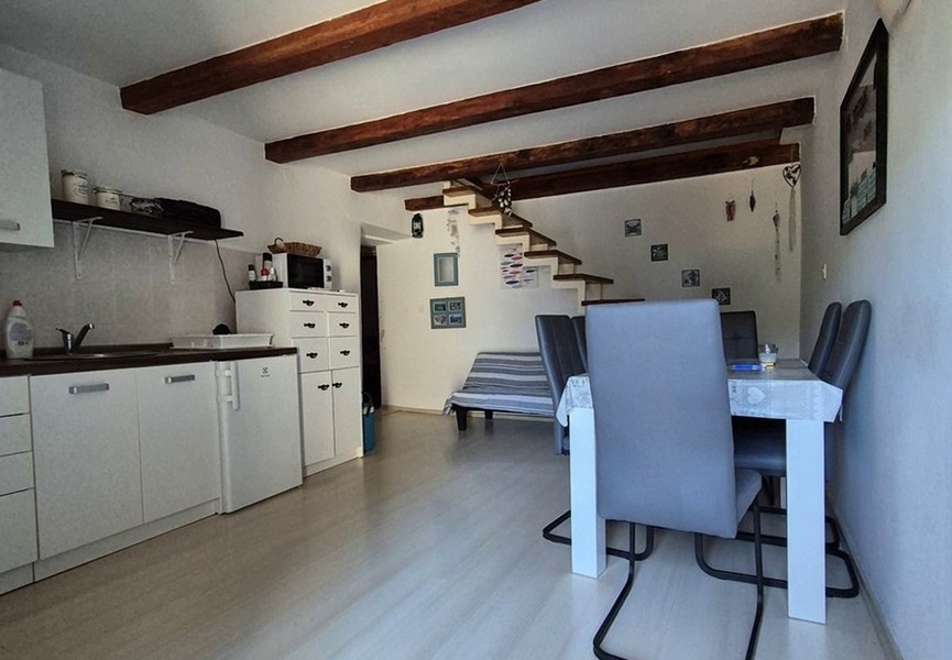 Kuchyňa s jedálenským stolom a schodiskom na poschodie