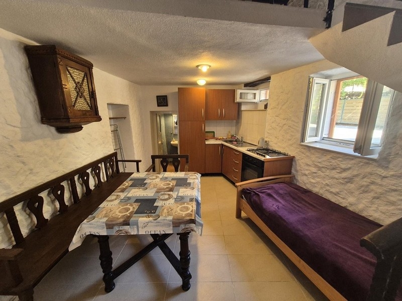 Jedálenský kút a kuchyňa s rustikálnym nábytkom na prízemí domu.