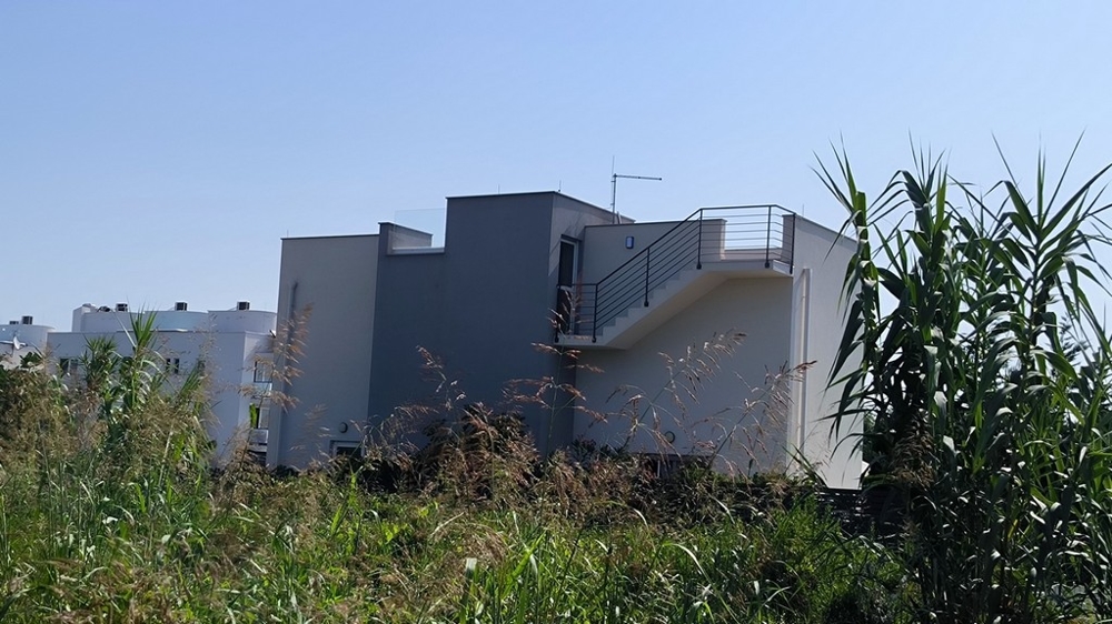 Zadný pohľad na dom s terasou a schodiskom na poschodie.