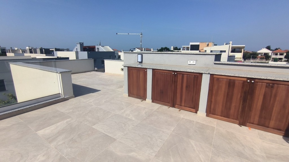 Priestranná strešná terasa so vstavaným dreveným nábytkom.