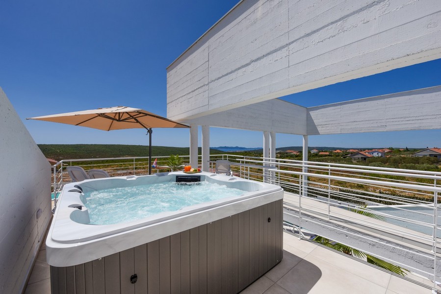 Vonkajšia vírivka na hornej terase s výhľadom na krajinu a more.