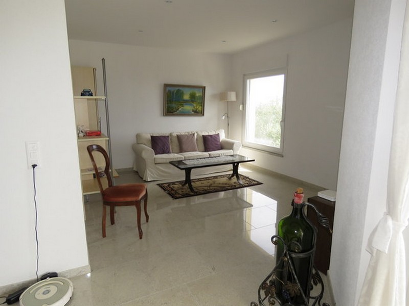 Obývacia izba s pohovkou, konferenčným stolíkom a veľkým oknom.