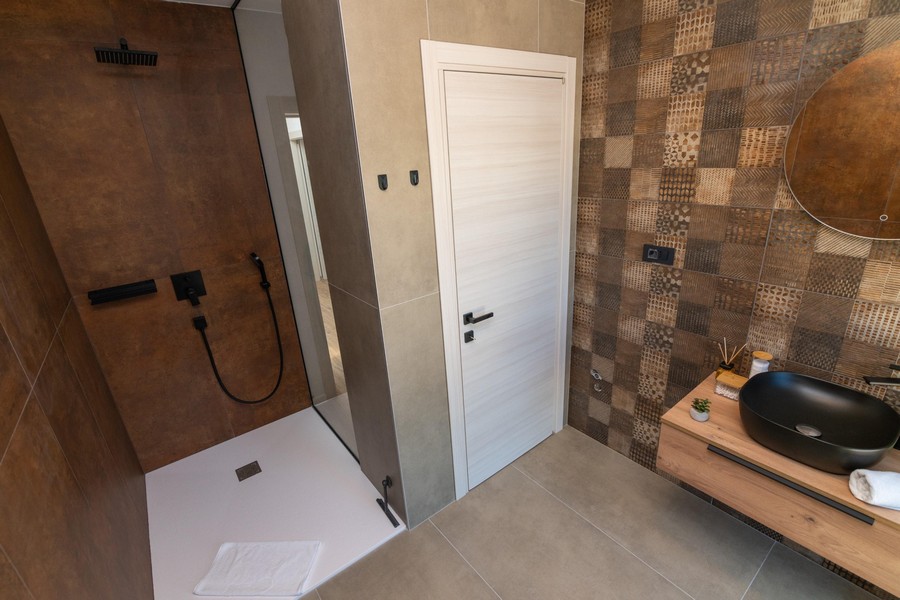 Moderná kúpeľňa s otvorenou sprchou a štýlovými obkladmi