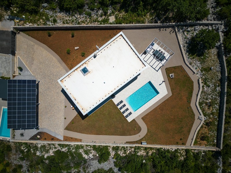 Pohľad zhora na nehnuteľnosť s vilou, bazénom a záhradou