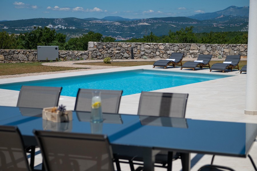 Vonkajší priestor s bazénom a ležadlami, výhľad na hory