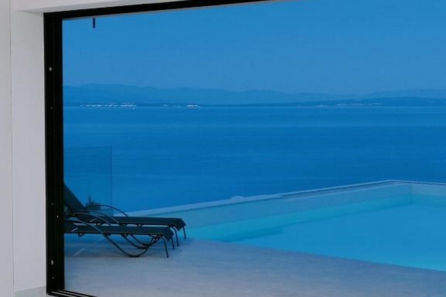 Obývacia izba s bazénom a výhľadom na more.