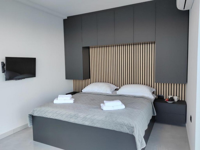 Manželská posteľ v spálni s drevenými detailmi