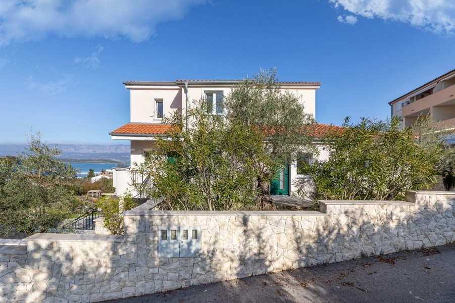 Pohľad spredu na dom so záhradou a výhľadom na more