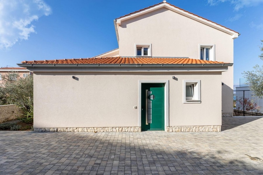 Vstupný priestor bytového domu so zelenou vstupnou bránou