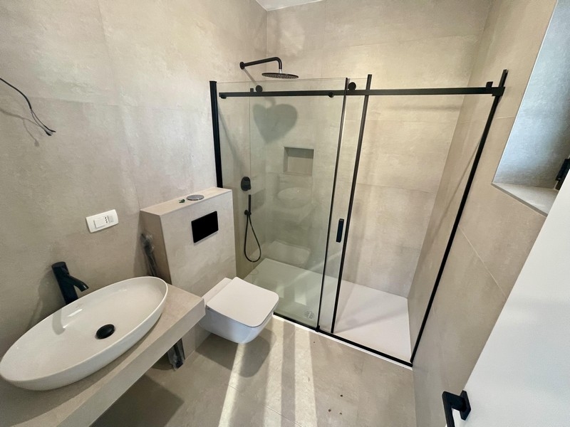 Moderná kúpeľňa so skleneným sprchovacím kútom