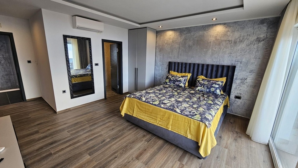 Spálňa s manželskou posteľou a subtílnym dizajnom stien