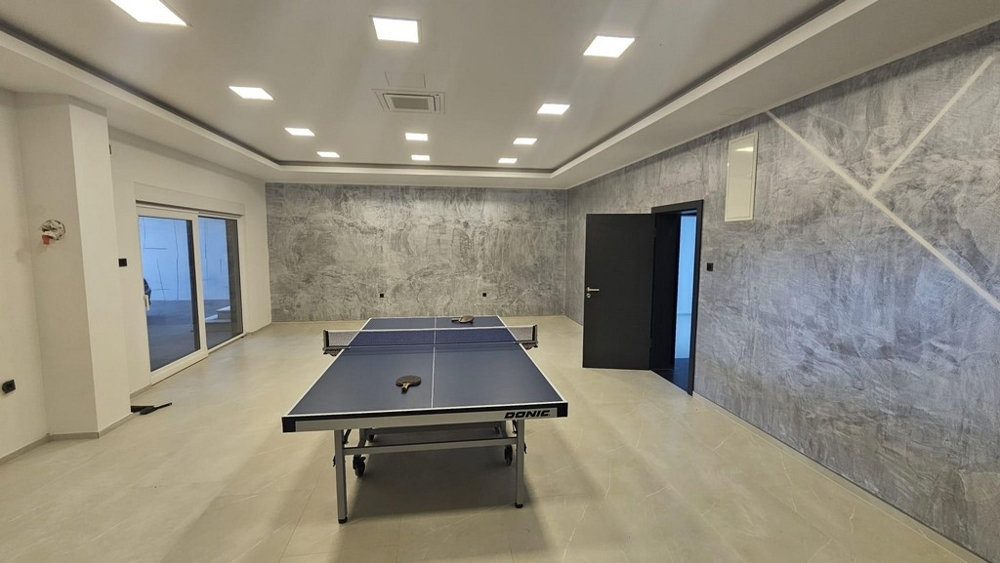Priestranná rekreačná alebo fitnes miestnosť so stolným tenisom