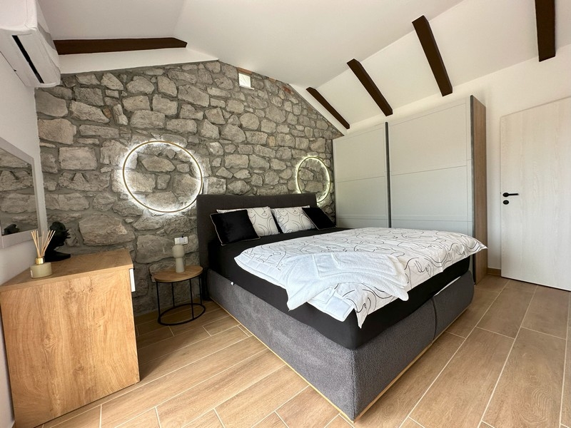 Spálňa s kamennou stenou a modernými prvkami