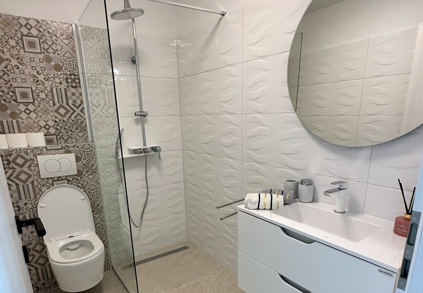 Moderná kúpeľňa so sprchovacím kútom a elegantným nábytkom