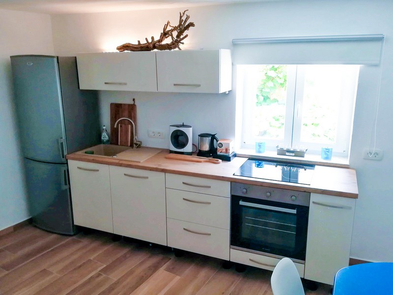 Svetlá kuchyňa s drevenými pracovnými doskami a moderným vybavením