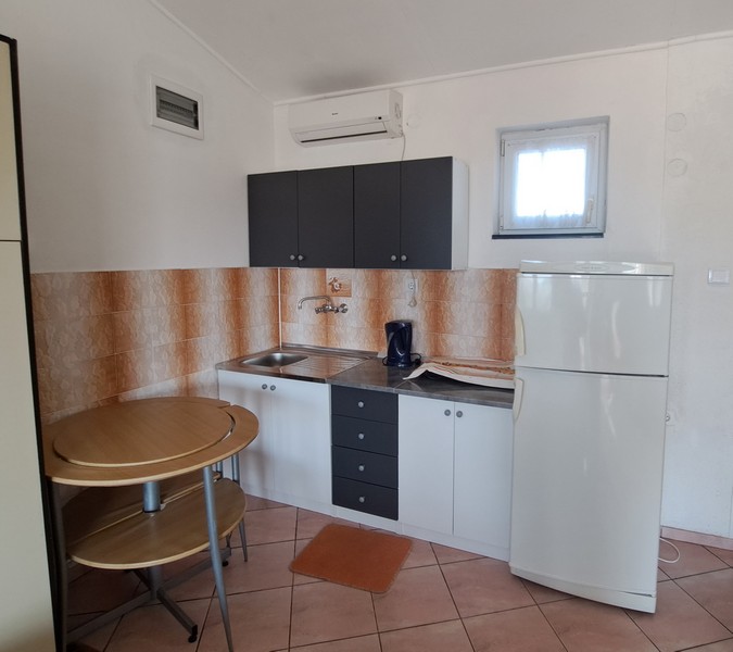 Kuchynský kút s malým stolíkom a chladničkou.