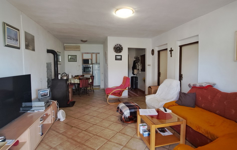 Obývacia izba s jedálenským kútom a kuchyňou v pozadí.