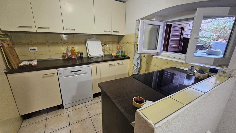 Moderná kuchyňa s bielymi čelami a oknami