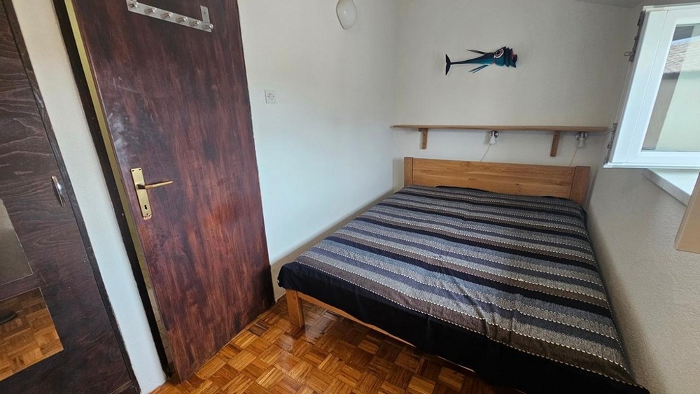 Spálňa s dreveným nábytkom a oknom