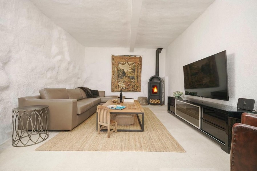 Obývacia izba so smart TV a útulným krbom.