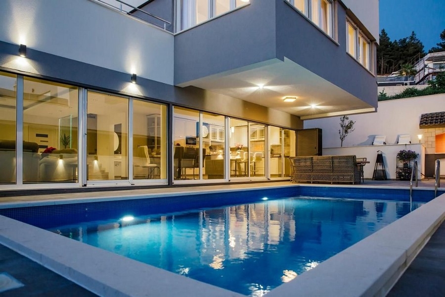 Vonkajší pohľad na vilu s bazénom za súmraku