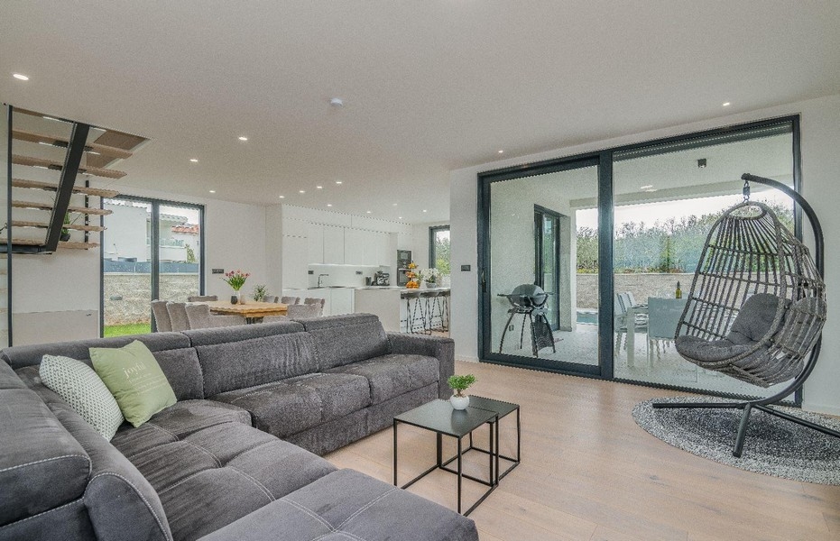 Otvorený obývací priestor s pohovkou, závesným kreslom a kuchyňou