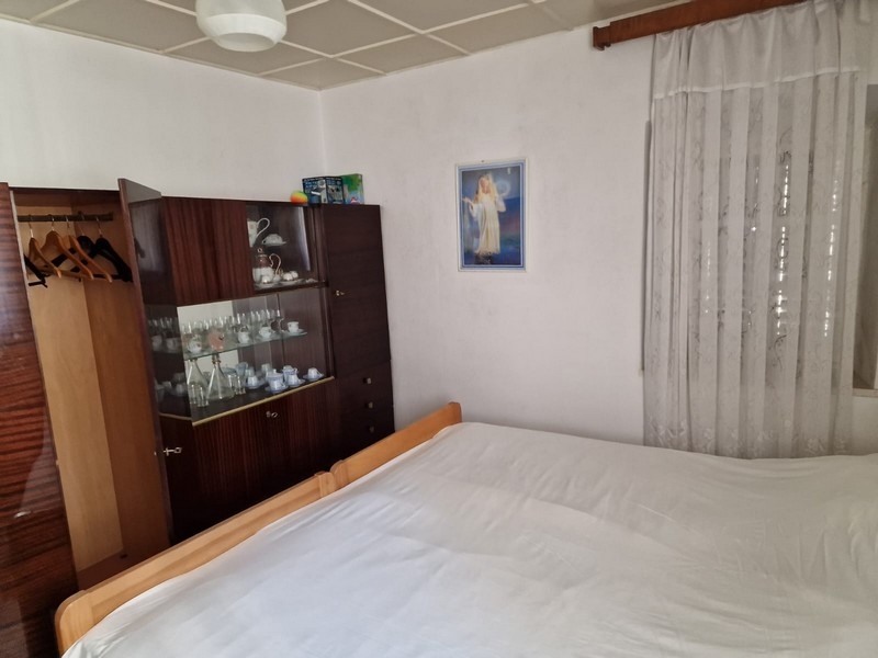 Spálňa s manželskou posteľou, nástennou skrinkou a nástennou maľbou