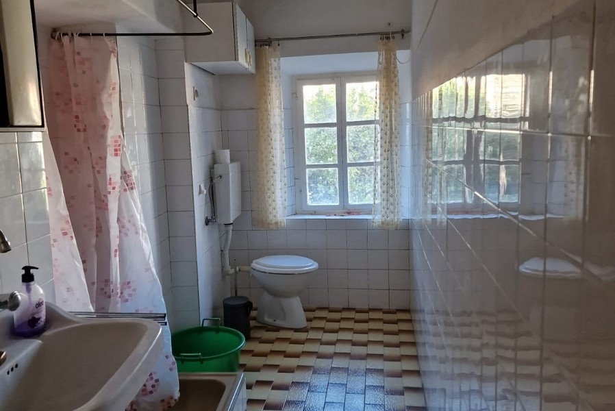 Kúpeľňa s oknom, sprchovým kútom, umývadlom a WC