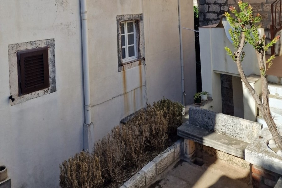 Vnútorné nádvorie s kamennými múrmi a malou lavicou