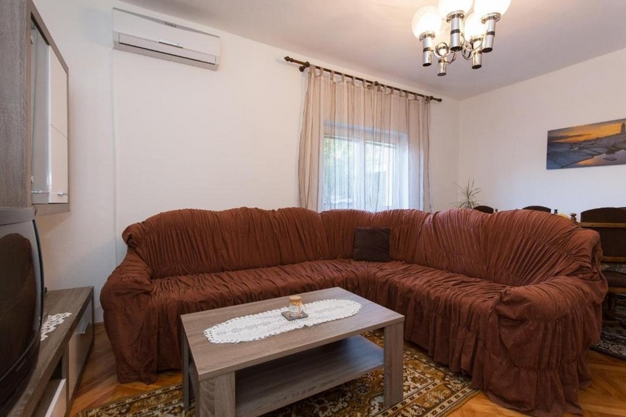 Obývacia izba s veľkou pohovkou a klimatizáciou